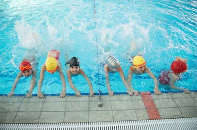 kids at swim lesson practice kicking